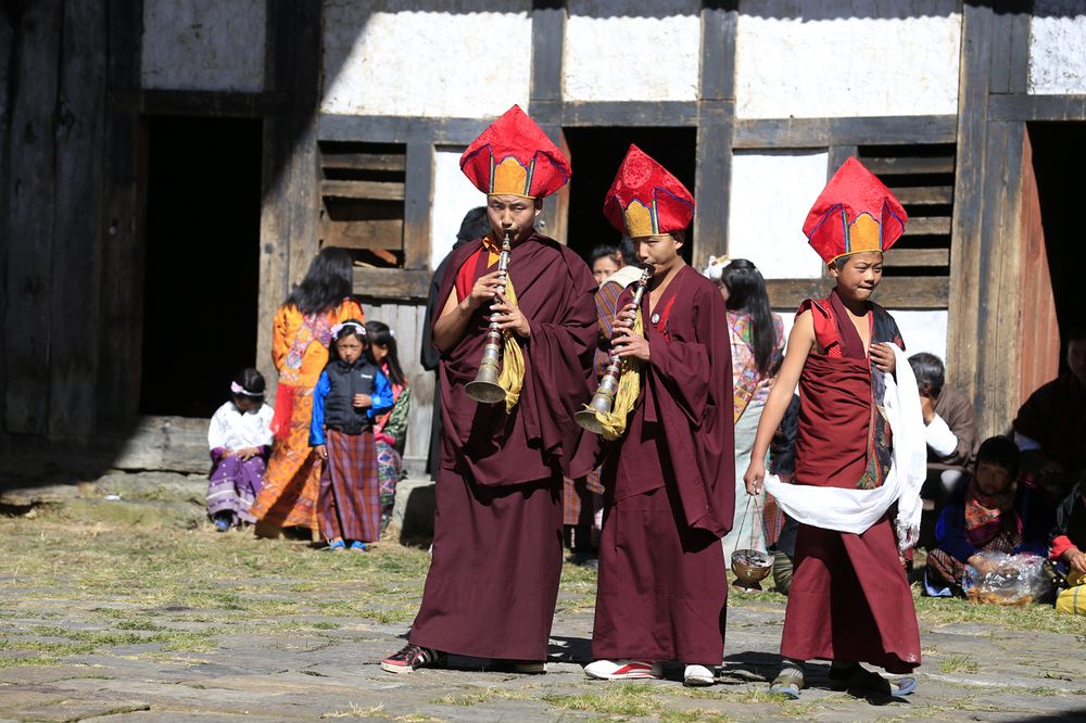 Young monks playing traditional horns in a festival procession