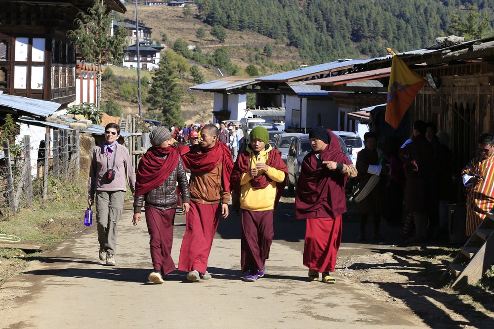 Monks walking through a Bhutanese village on festival day