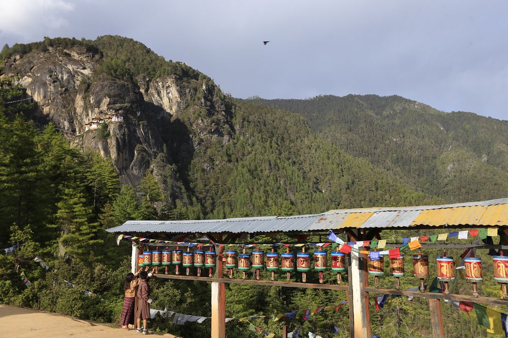 Children spinning prayer wheels at a roadside shrine below the Tiger's Nest trail